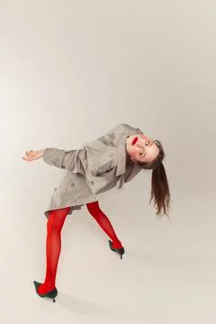 Portrait of young stylish girl posing in red tights and coat posing isolated Stock Photos