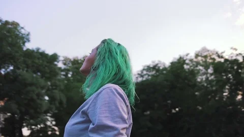 Portrait of young stylish hipster woman with green looking at sky, slow motion Stock Footage