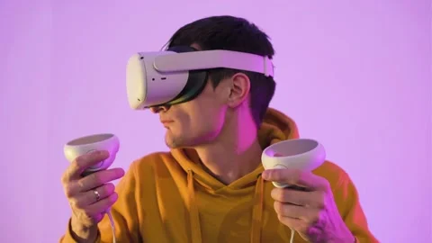 Portrait of young stylish man using virtual reality headset with joysticks. Stock Footage 225153068