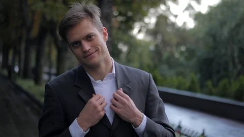 Portrait of young successful confident businessman straightens clothes in the Stock Footage