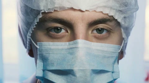 Portrait of a young surgeon or intern taking a mask off his face Stock-Footage 120940981