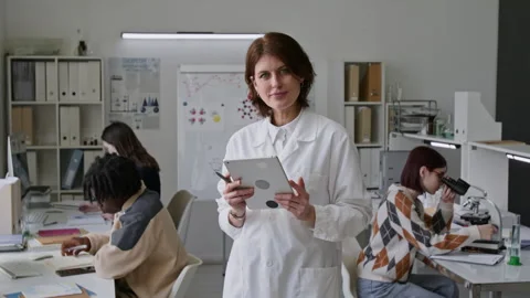 Portrait of Young Teacher in Lab Coat Holding Digital Tablet During Class Stock Footage 312322341
