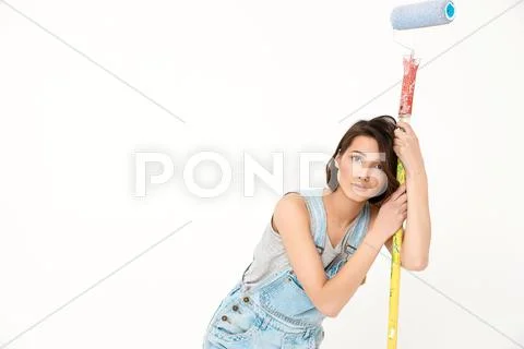 Portrait of young tired beautiful girl, holding painting rolle Stock Photos
