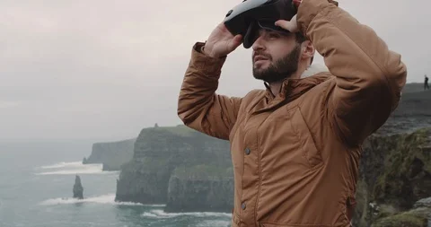 Portrait of a young toy playing with a VR on the top of Cliffs with amazing Stock Footage 101589818