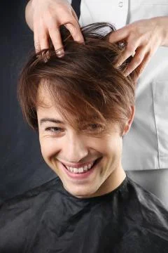 Portrait of a young white boy while cutting hair in the hair salon  Stock Photos