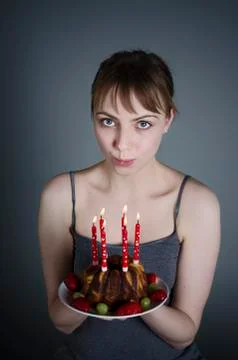 Portrait of young woman blowing birthday candles, close up Stock Photos