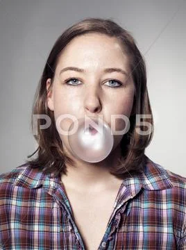 Portrait Of Young Woman Blowing Bubble Gum