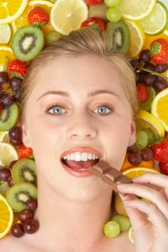 Portrait Of Young Woman Eating Chocolate Stock Photos