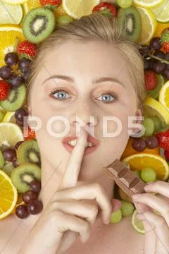 Portrait Of Young Woman Eating Chocolate Stock Photos