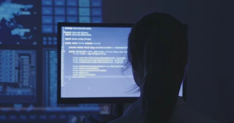Portrait of young woman hacker programmer working at a computer in the data Stock Footage 95647313