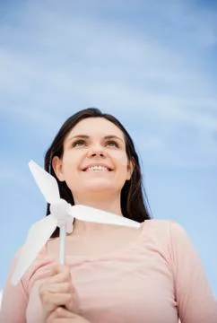 Portrait of young woman holding minature wind turbine Stock Photos