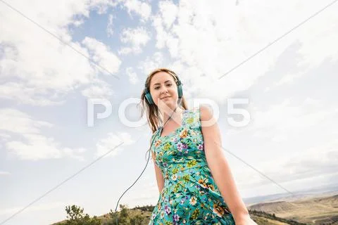 Portrait Of Young Woman Listening To Headphones In Hilly Landscape, Bridger,