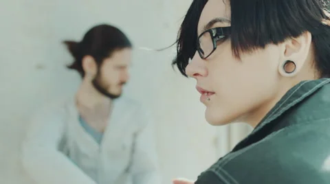 Portrait of a young woman in profile hipster. In the background is her boyfriend Stock Footage