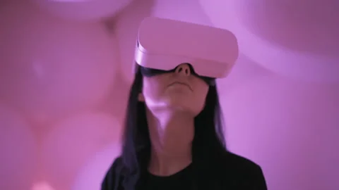 Portrait of young woman using VR metaverse headset in abstract virtual space Stock Footage 217537945
