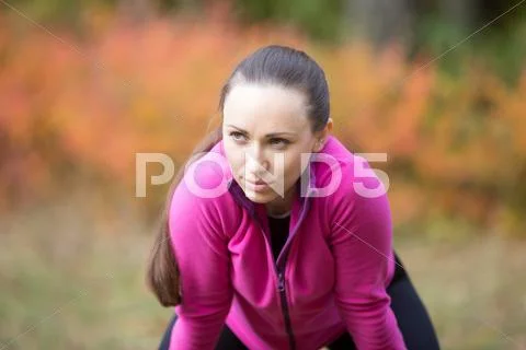 Portrait of a young woman warming up outdoors in the fall Stock Photos