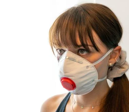 Portrait of young woman wearing medical N95 face mask with white background Stock Photos