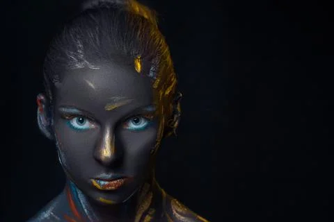 Portrait of a young woman who is posing covered with  black paint Stock Photos