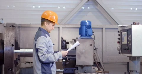 Portrait of a young worker in a helmet at a large metalworking plant. An Stock Footage 160657259