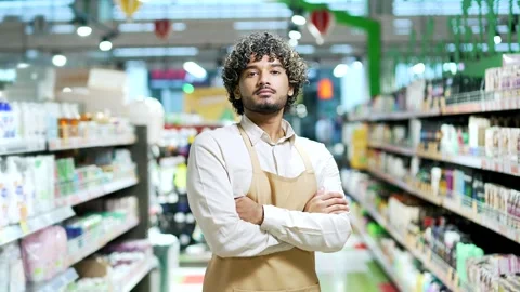 Portrait young worker man salesman in apron looking at camera in grocery store  Stock Footage 297470493