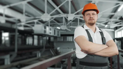 Portrait of a young worker in a uniform and a hard hat looking at the camera. Stock Footage 306815022