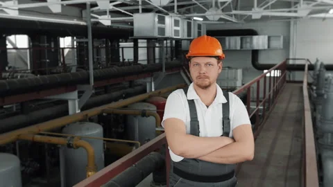 Portrait of a young worker in a uniform and a hard hat looking at the camera. Stock Footage 306815497
