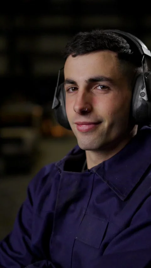 Portrait of young worker using protective noise reduction headphones Stock Footage 266460010