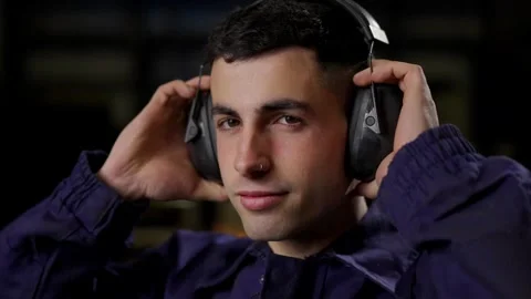 Portrait of young worker using protective noise reduction headphones Stock Footage 267156392
