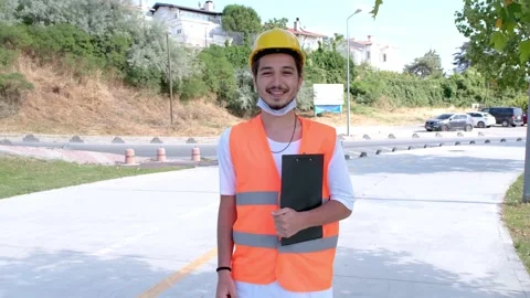 Portrait of young worker with white hardhat and face mask Stock Footage 136924550