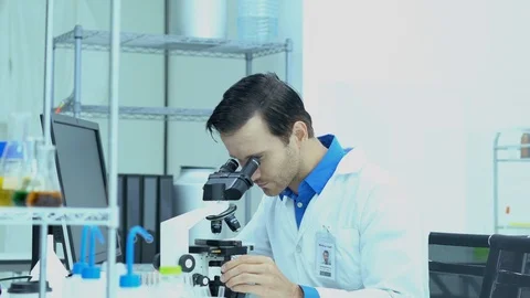 Portraits of scientists looking through microscope and observe in modern lab. Stock Footage 106856309