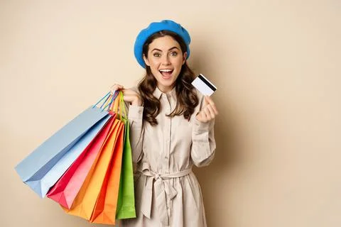 Portrat of trendy feminine girl posing with shopping bags from store and credit Stock Photos