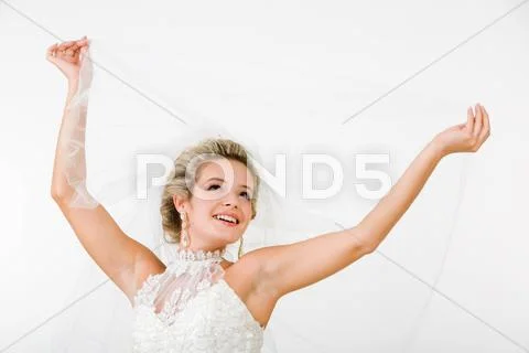 Portray of happy beautiful fiancee raising hands with veil Stock Photos