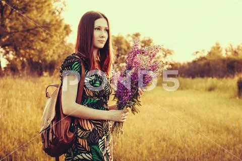 Portret red-haired woman with a bouquet of wildflowers. Stock Photos