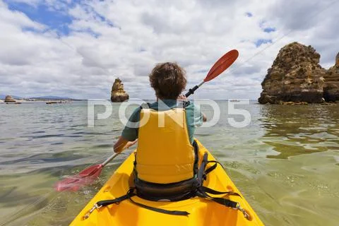 Portugal, lagos, teenage boy rowing kayak Stock Photos