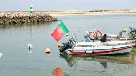 Portuguese flag waves in the wind on a small boat on the water, 4K Stock Footage 110899053