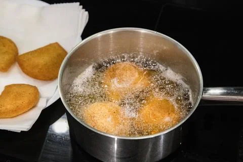Portuguese rissois being fried in hot oil Stock Photos