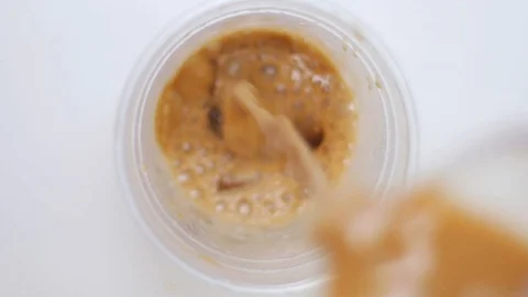 Poruing Iced Coffee into Plastic Cup Slow Mo Stock Footage 100650377