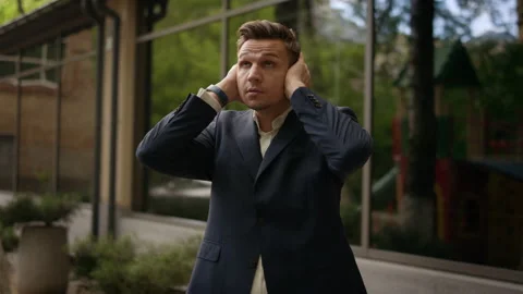 Pose I CAN'T HEAR, young businessman closes his ears by his hands. Financial Stock-Footage 134147797