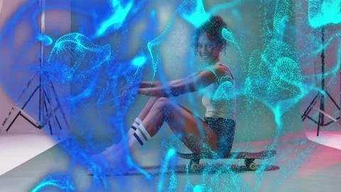 Posing model adjusting on skateboard in studio, white top, shorts, blue mesh Stock Footage 332867109