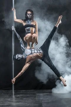 Posing of pole dance couple in dark studio Stock Photos