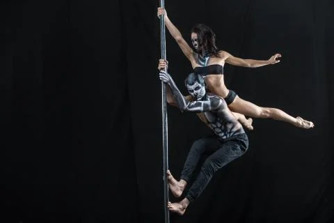Posing of pole dance couple in dark studio 스톡 사진