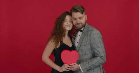 Posing on red background and holding heart. Love concept. Stock Footage 147120053