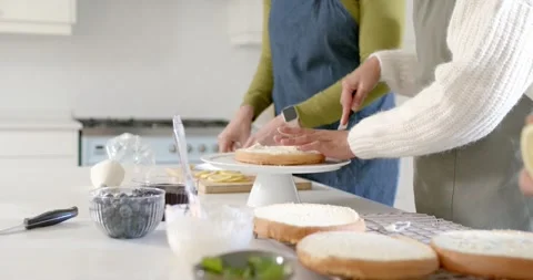 Positioning layer on rotating stand, two bakers are steadying, spreading Stock Footage 347307405