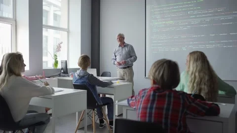 Positive aged teacher asking question explaining lesson to students Stock Footage 142491785