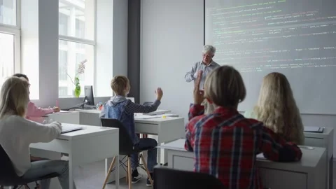 Positive aged teacher asking students explaining computer programming Stock Footage 142491745