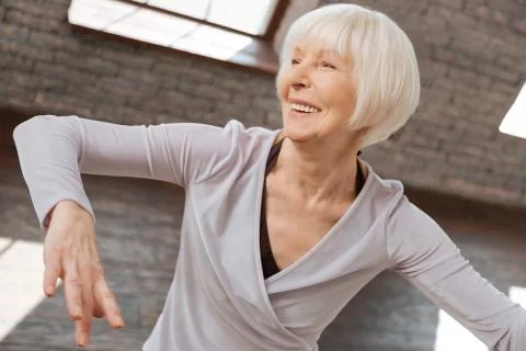 Positive aging woman learning step at the dance lesson Stock Photos