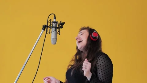 The positive amusing brunette female singer having fun sings song in earphones Stock Footage 134205980