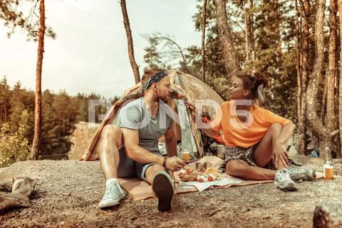 Positive beautiful woman feeding her boyfriend with a tomato Stock Photos