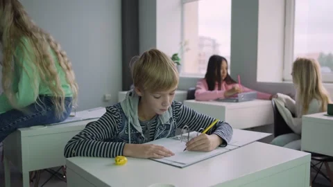 Positive boy fulfilling assignment during break in school Stock Footage 142495638