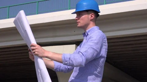Positive cheerful architect man looking over blueprint plan appreciate good work Stock Footage