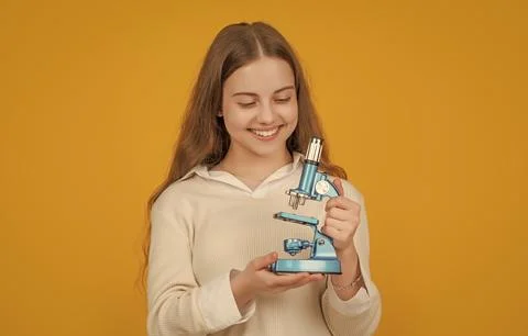 Positive child with microscope on yellow background Stock Photos